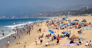 Photo of people on the beach next to the ocean